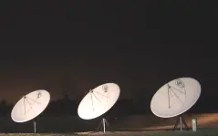 Photo of radio telescopes listening to the sky at night.